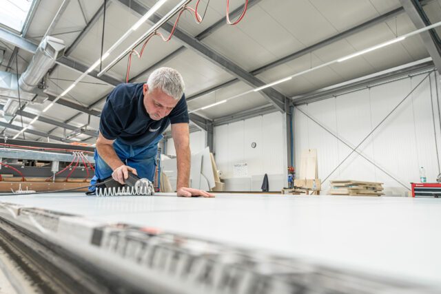 Zuschnitt großer Blechtafeln in der Werkstatt der Tischer Manufaktur – ein Mitarbeiter arbeitet konzentriert an der Blechsäge.