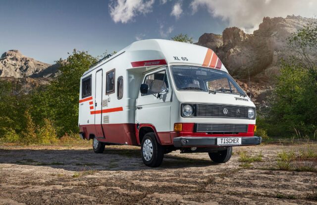 Tischer Classic XL65-243_A2 -Klassischer Tischer Kastenwagen mit rot-weißem Design, seitlich geparkt auf Wiese.