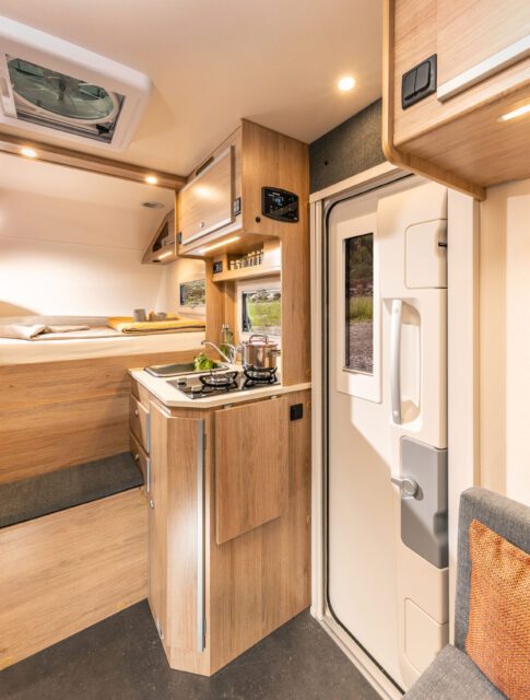 Blick in die Küche der Tischer 260SP Flatbed mit Spüle, Herd und Oberschränken.