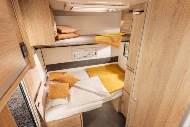 Innenansicht Tischer Trail 260SP mit Doppelbett unten und optionalem Etagenbett über dem Wohnbereich.