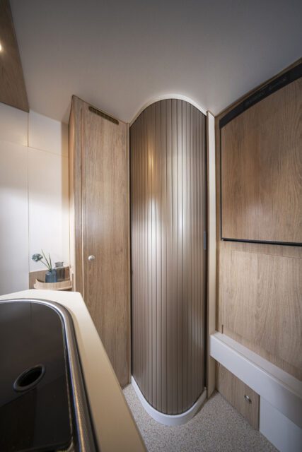 Seitlicher Blick auf geschlossenes Bad mit Schiebetür in Holzoptik – Tischer Wohnkabine