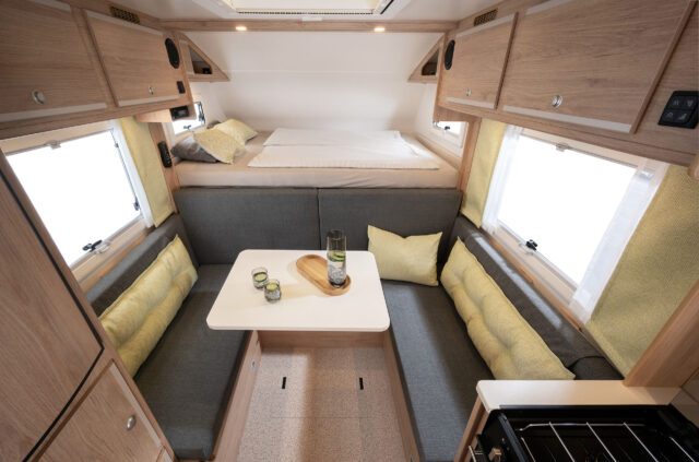 Komplette Sitzgruppe mit Esstisch und gelben Kissen in der Tischer Box 340S auf MAN TGE.