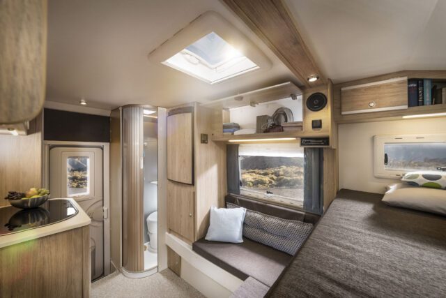 Innenraum der Tischer Kabine mit Sitzbereich und Blick auf die geöffnete Dusche mit Duschwanne.