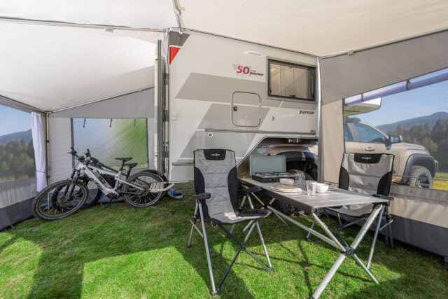 Tischer Vorzelt mit Möblierung und Fahrrädern, montiert an Absetzkabine