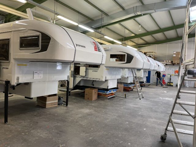 Produktionshalle mit mehreren Tischer Wohnkabinen im Aufbau – Fertigungslinie in der Werkstatt.