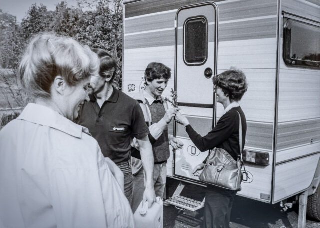 Tischer Classic Community 1983 -Vier Personen vor einer klassischen Tischer-Kabine, schwarzweiß.