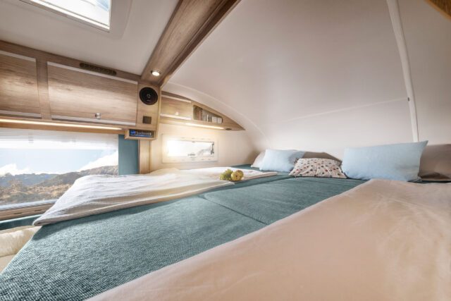 Tischer Trail275S - Großzügiger Schlafbereich im Alkoven mit seitlichem Fenster und Himmelspanorama durch Dachluke.