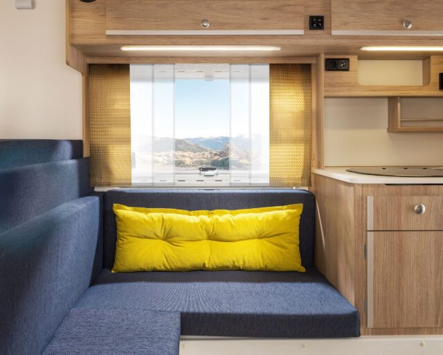 Tischer Innenausstattung mit blauen Polstern und leuchtend gelbem Rückenkissen.