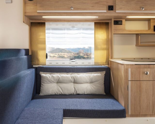 Tischer Wohnkabine: Sitzpolster in Blau, Vorhänge in Gelb.