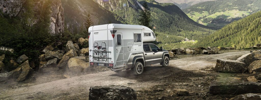 Tischer_AmarokTrail230S_Tischer Wohnkabine – Rückansicht beim Offroad-Einsatz in den Bergen.