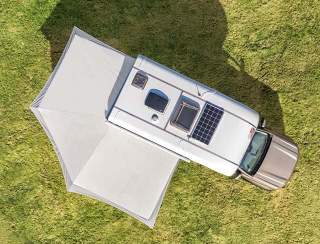 Draufsicht: Aufbau mit Solarpanel, Tischer Vorzelt und Pickup auf Wiese.