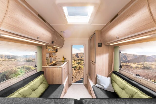 Innenansicht der Trail Box 200: Blick vom Bett Richtung Tür, mit Küche und Sitzbank.