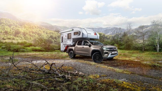 Tischer 230S montiert auf Pickup im Gelände, umgeben von Bergen und Wäldern.