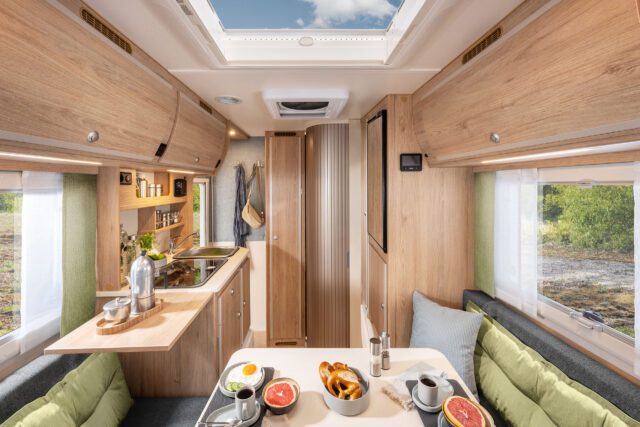 Innenansicht der Tischer 260: Blick durch Wohnkabine mit Sitzgruppe, Küche und Dachhaube.
