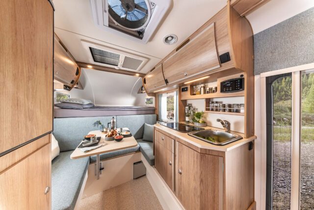 Innenansicht der Trail Box 280S mit Küchenzeile, Oberschränken und Sitzgruppe in modernem Design.