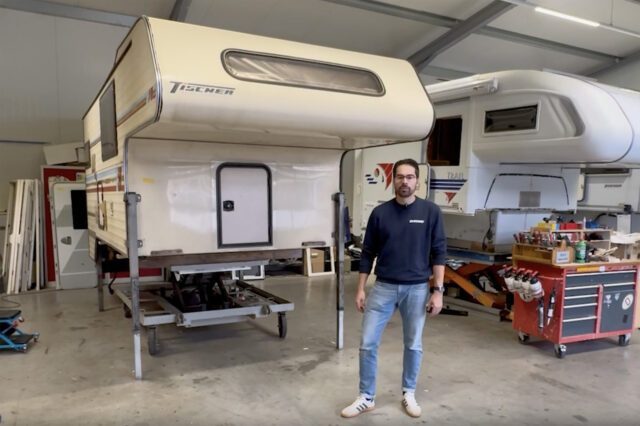 Tischer-Kabine freistehend auf Stützen, daneben steht Mitarbeiter in Halle.